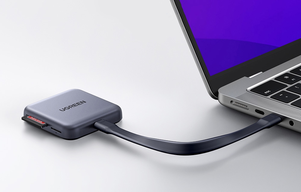 Adaptorul Ugreen CM898 cu un card SD conectat la un laptop.