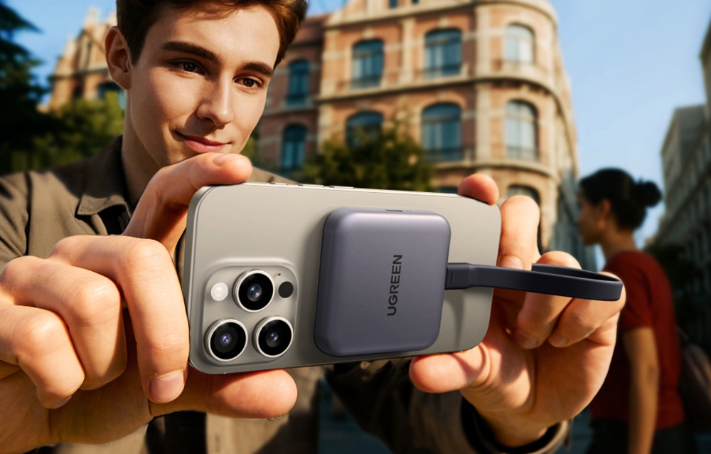 Un barbat tinand un smartphone la care este conectat adaptorul Ugreen CM898.