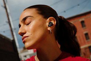 Woman wearing Bose QuietComfort Ultra Earbuds (2nd Gen) outside.