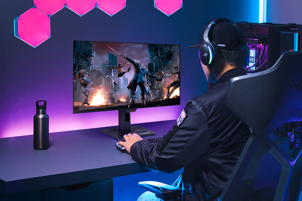 A gamer playing on a gaming setup featuring a monitor and PC, a thermos can be seen on the desk as well.