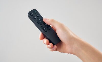 Imagine a unei maini care opereaza o telecomanda