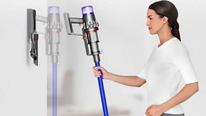 O femeie punand aspiratorul Dyson V11™ in statia de incarcare de pe perete