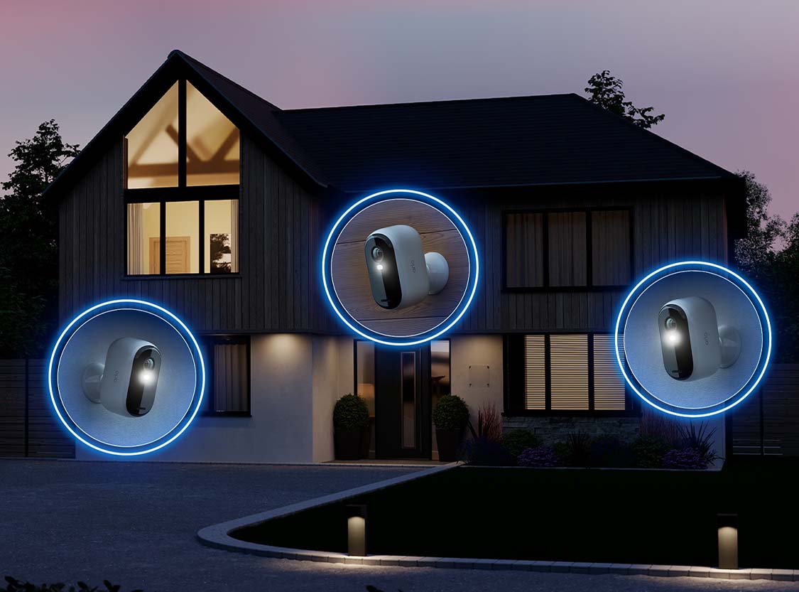 O casa pe timp de noapte cu 3 camere Arlo instalate pentru o protectie suplimentara